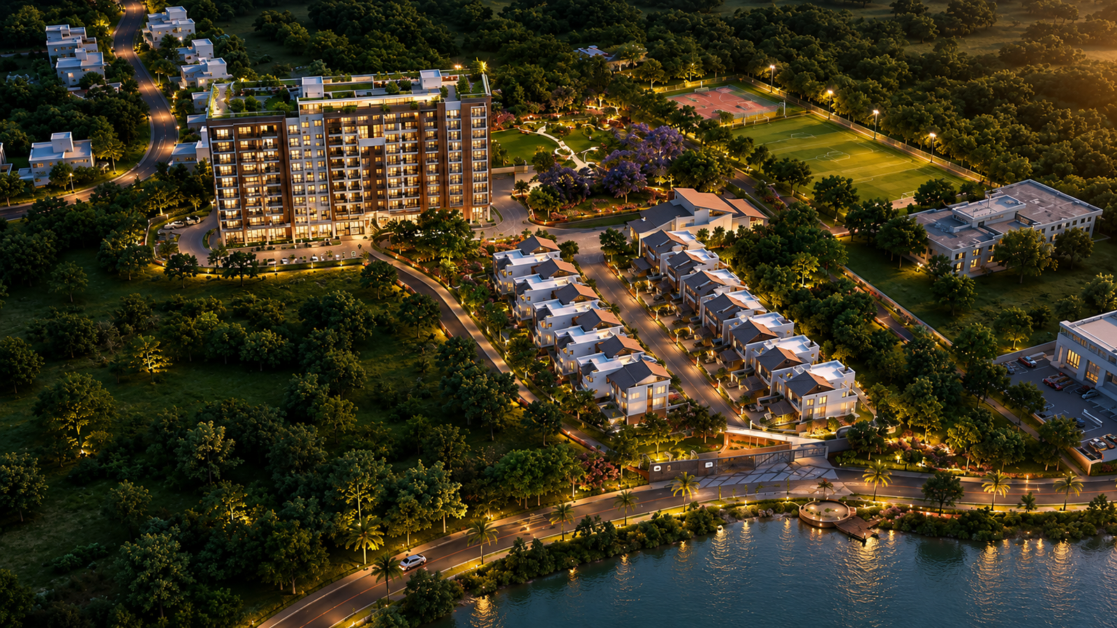 High-resolution aerial view of a luxurious waterfront residential development at twilight, featuring modern villas, a multi-storey apartment building, landscaped gardens, sports fields, illuminated roads, and a lakeside promenade surrounded by dense green